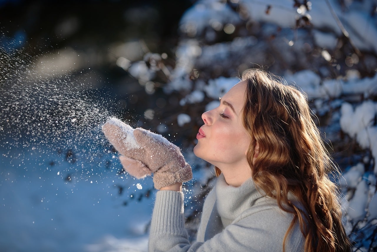 Frau bläst Schnee